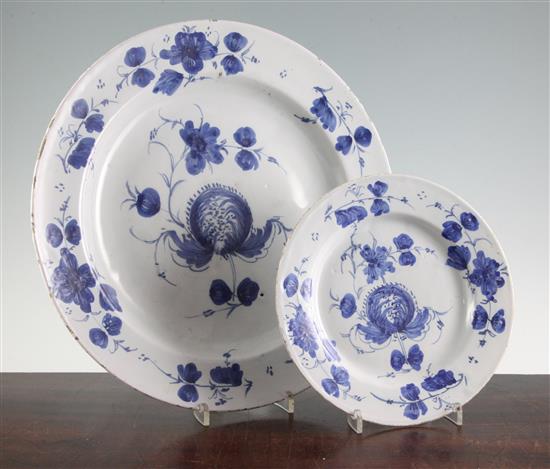 A Glasgow delft ware charger and a similar plate, late 18th century, 35.5cm and 22.5cm, hairline crack to charger